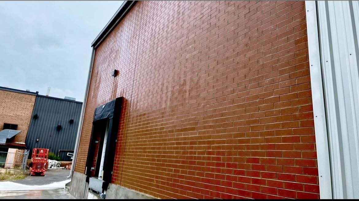 clean brick wall, side of a commercial building after commercial pressure washing.