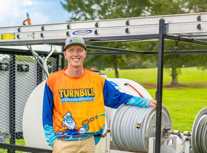 Jacob Turnbill beside pressure washing work truck